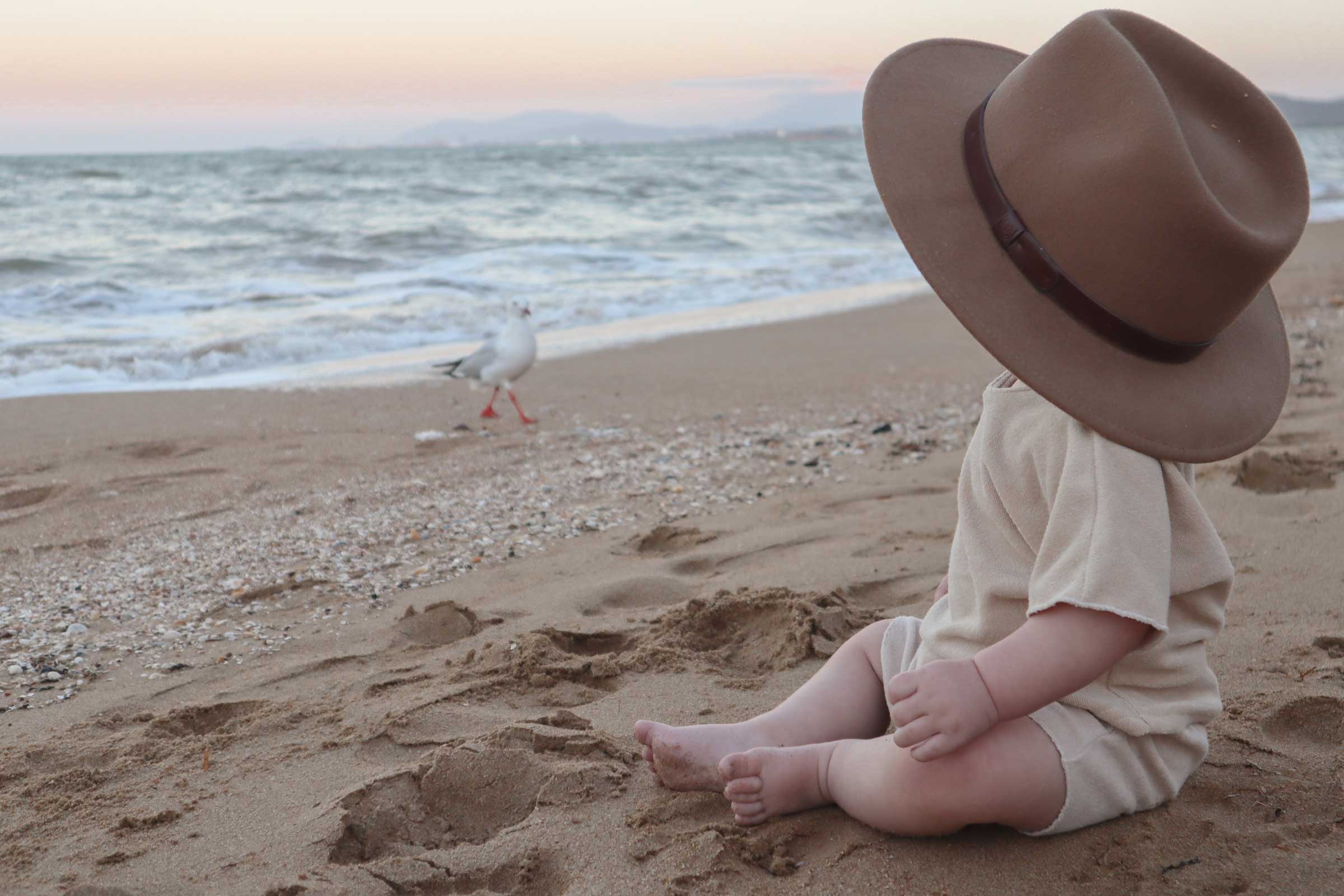bebe sur la plage avec chapeau